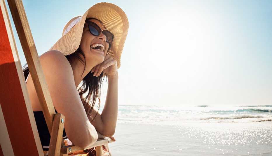 A woman is laughing at the beach