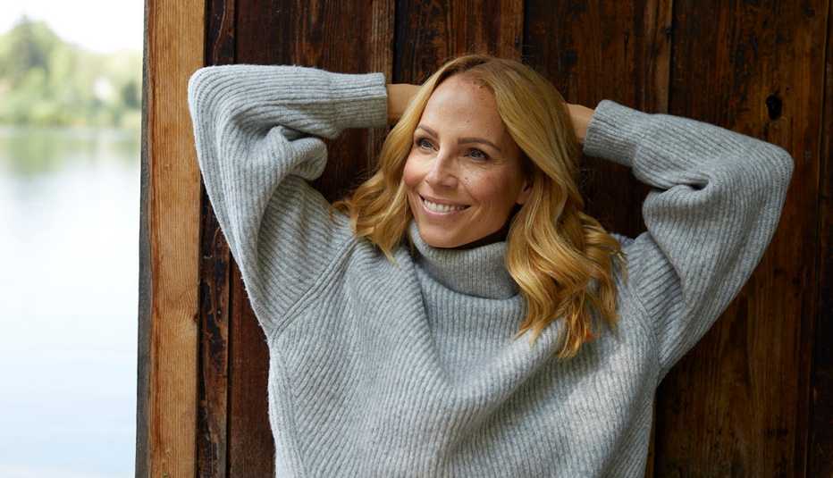 A woman wearing a sweater smiling outside