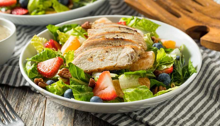 A poppyseed salad with chicken, strawberries and blueberries