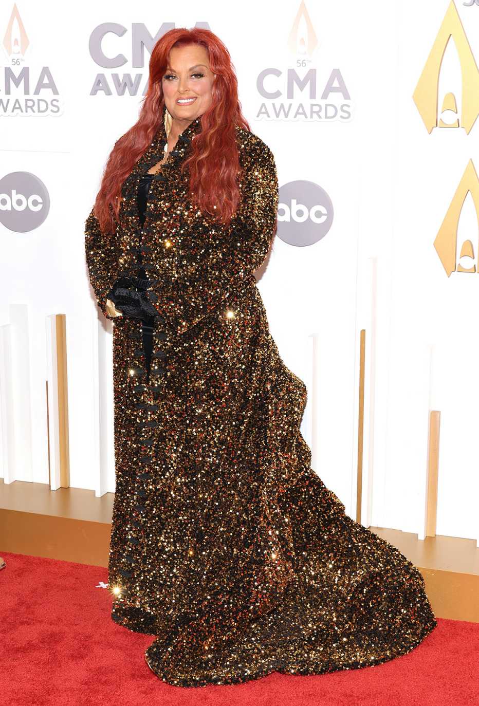 Wynonna Judd on the red carpet in a shimmery gold dress at the 56th annual CMA Awards