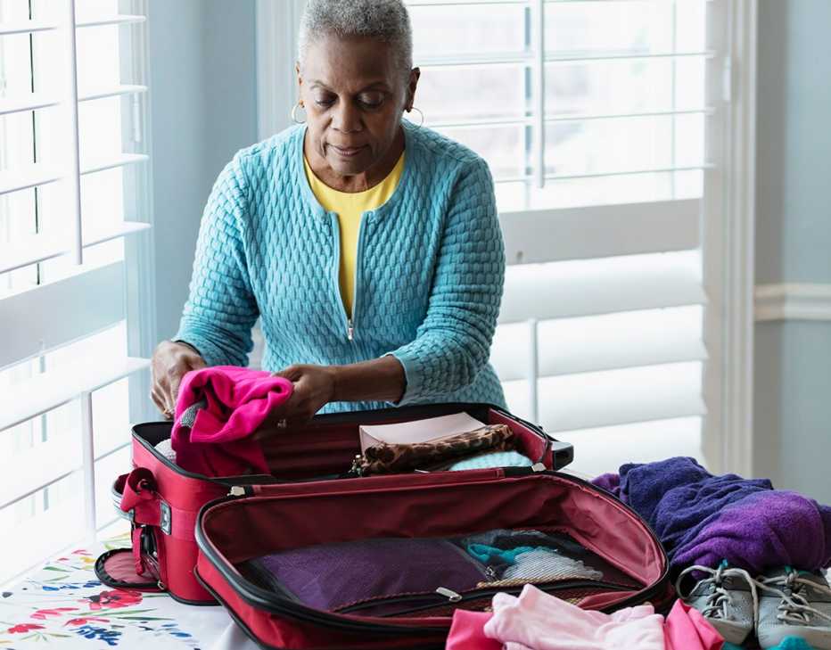 A woman at home packing a suitcase for a trip
