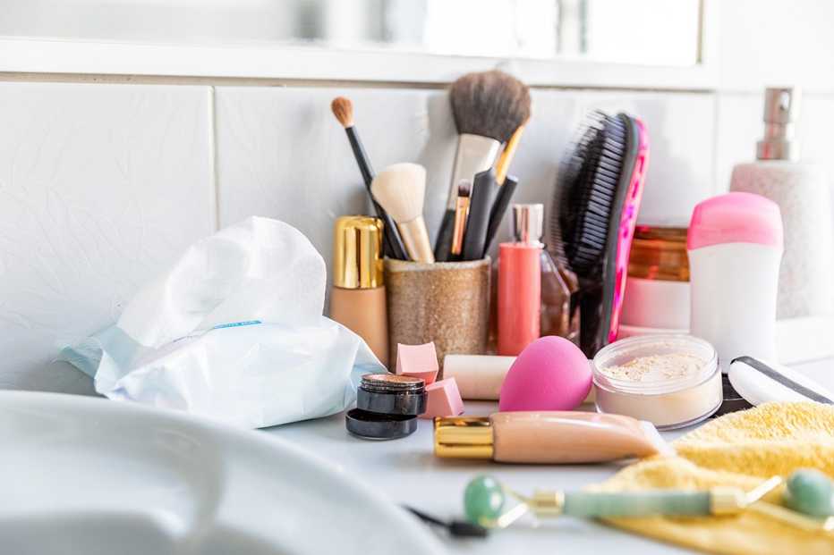 Messy and clutter cosmetics products and tools lying around on a bathroom sink