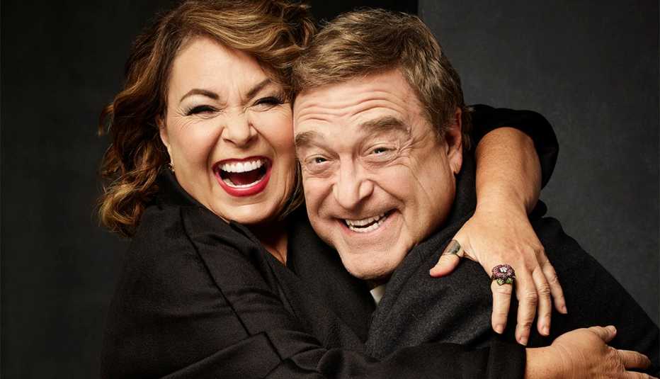 Roseanne Barr and John Goodman hugging and laughing