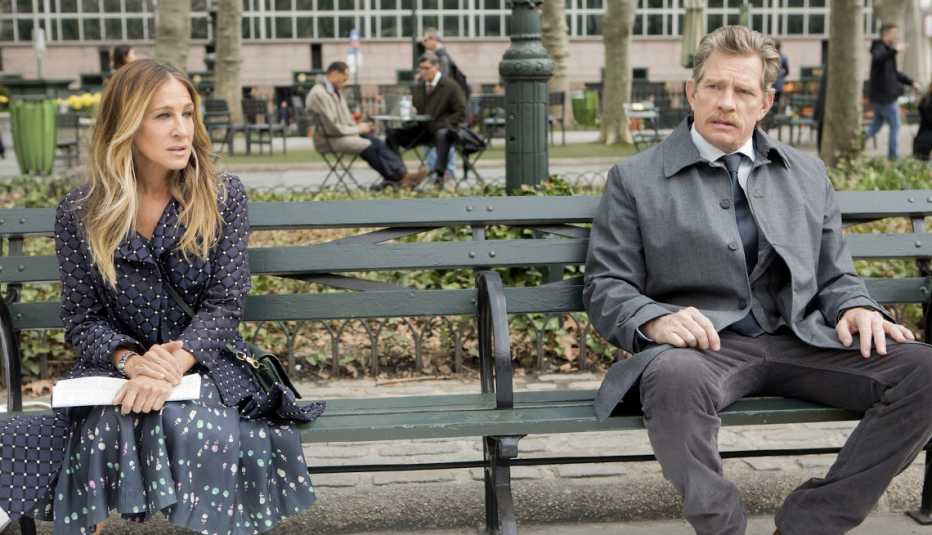 Actors Sarah Jessica Parker and Thomas Hayden Church sitting on a park bench together