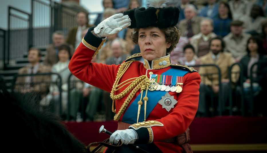 Olivia Coleman, starring as Queen Elizabeth II, gives a salute while riding a horse in a scene from The Crown