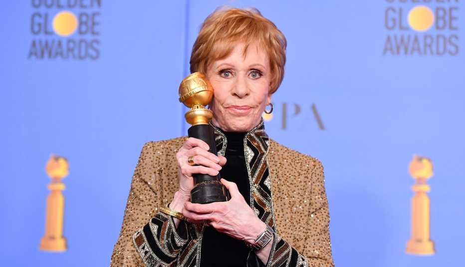 Carol Burnett holds the Golden Globe television special achievement award named after her