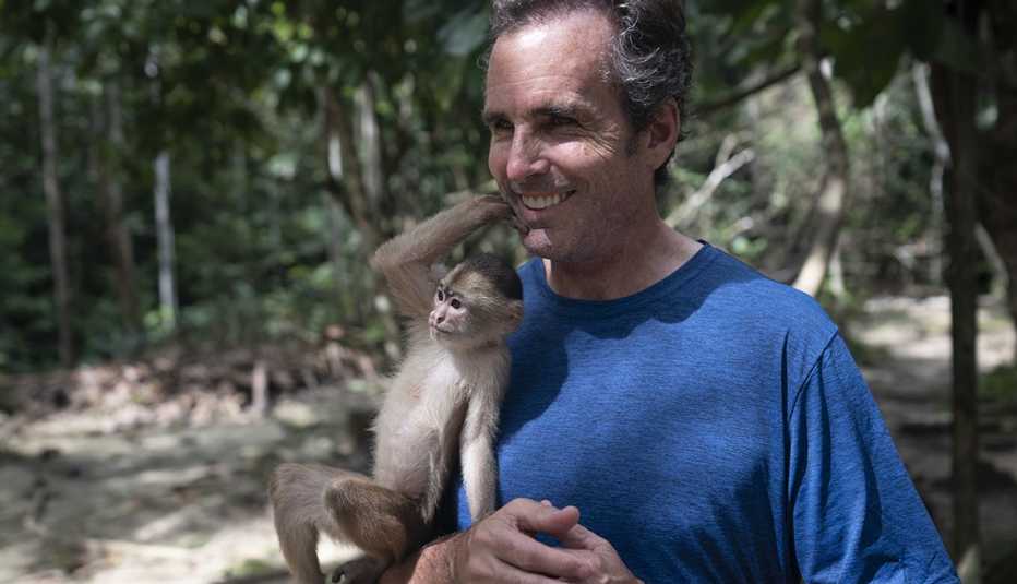 Bob Woodruff holds a monkey in the Amazon of Columbia