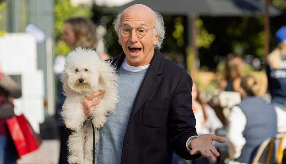 Larry David holding a dog in his arm in the HBO series "Curb Your Enthusiasm."