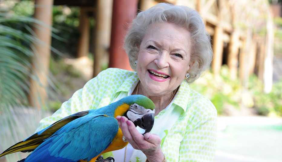 Actress Betty White holding a parrot in her hand