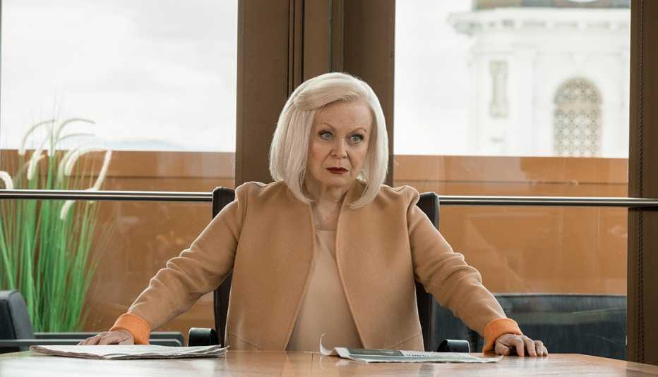 Actress Jacki Weaver sitting in a chair behind a desk in a scene from Season 5 of Yellowstone
