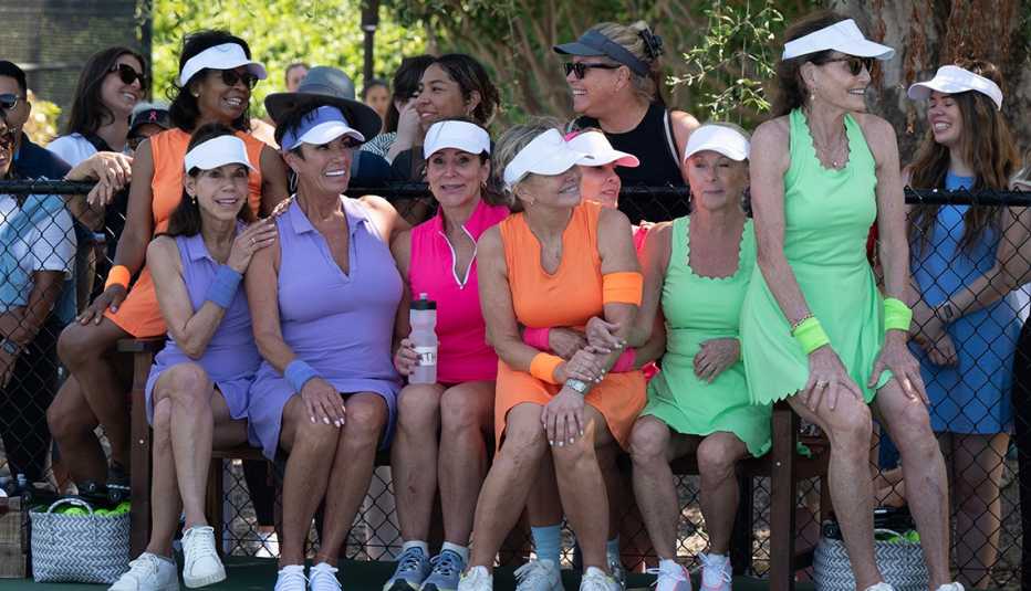 Some of the women of "The Golden Bachelor" sitting on a bench together on the pickleball court.