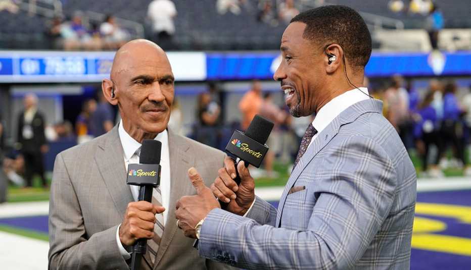 nbc sports analysts tony dungy and rodney harrison talking to each other on the field during the nfl game between the los angeles rams and buffalo bills