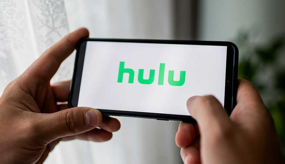 a hulu logo displayed on a smartphone being held in the hands of person