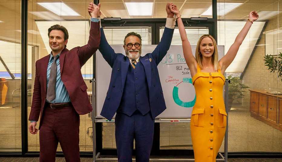 chris evans andy garcia and emily blunt raise their arms in the air together in a scene from the film pain hustlers