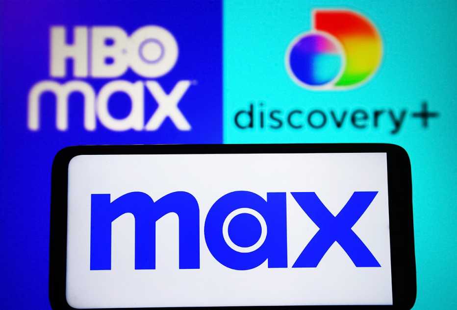 The Max logo is shown on a smartphone with the HBO Max logo and Discovery Plus logo displayed behind it