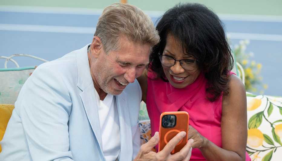 "The Golden Bachelor" Gerry Turner and Sandra smiling together while looking at a smartphone