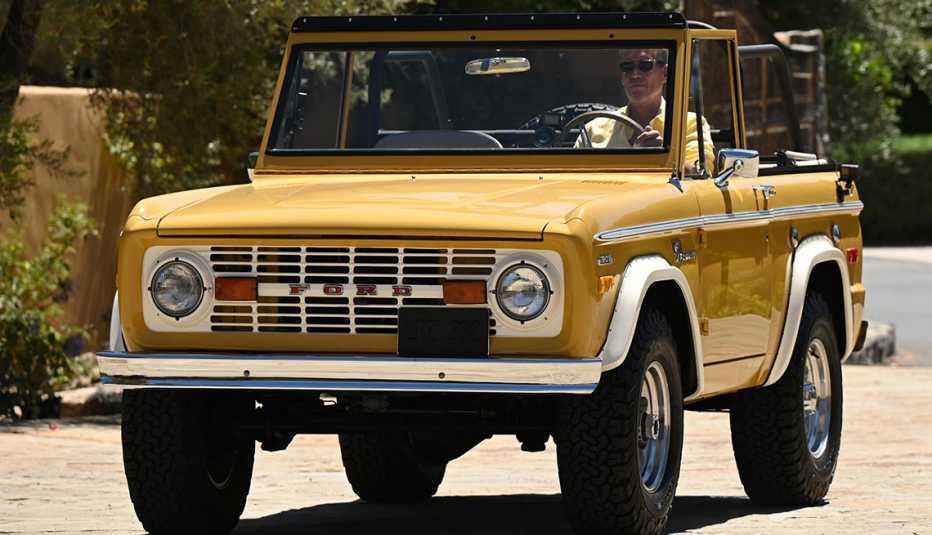 the golden bachelor gerry turner driving a classic yellow ford sport utility vehicle