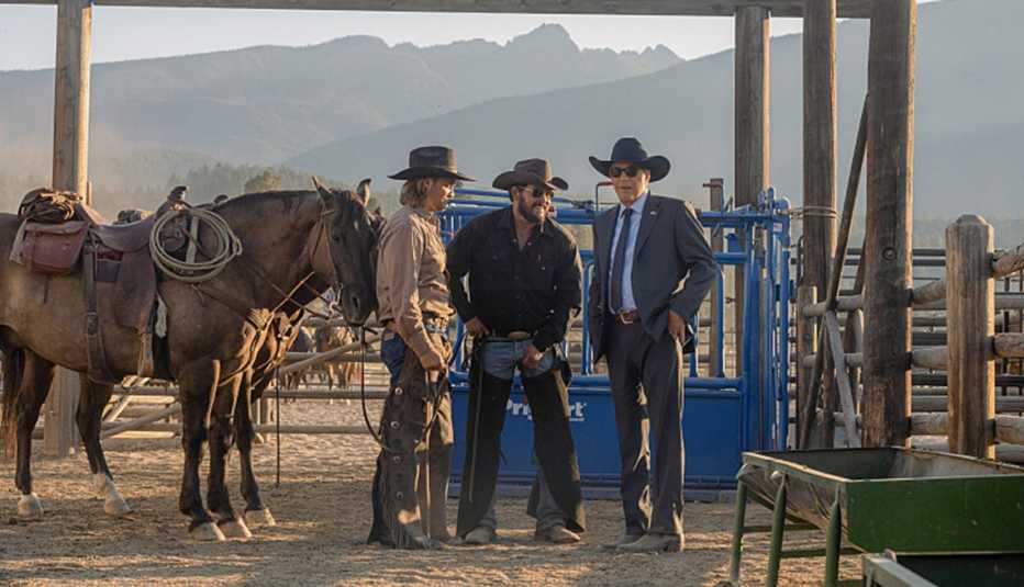 Luke Grimes, Cole Hauser and Kevin Costner talking together out on the ranch in Yellowstone