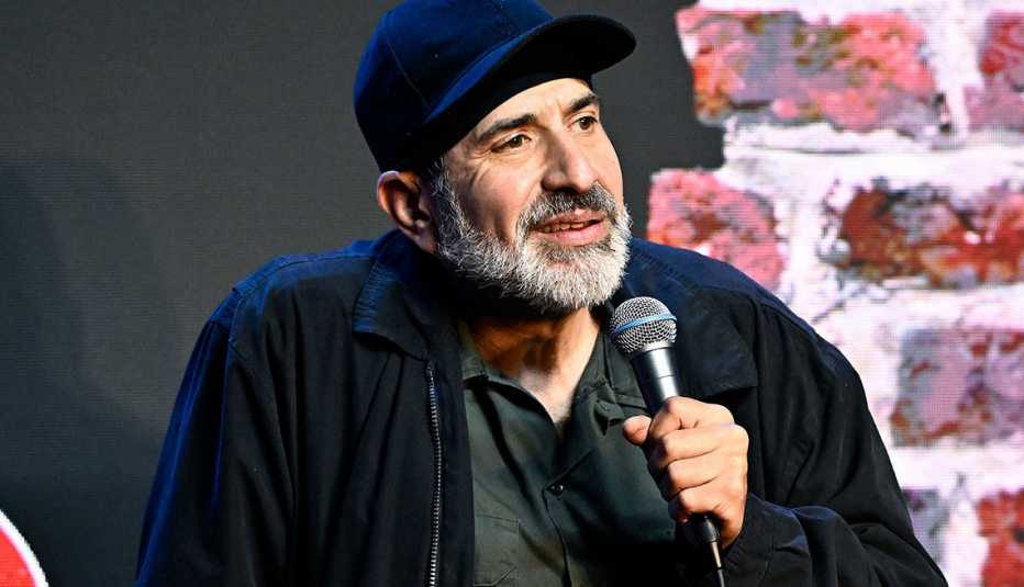 Comedian Dave Attell holding a microphone during a standup comedy act