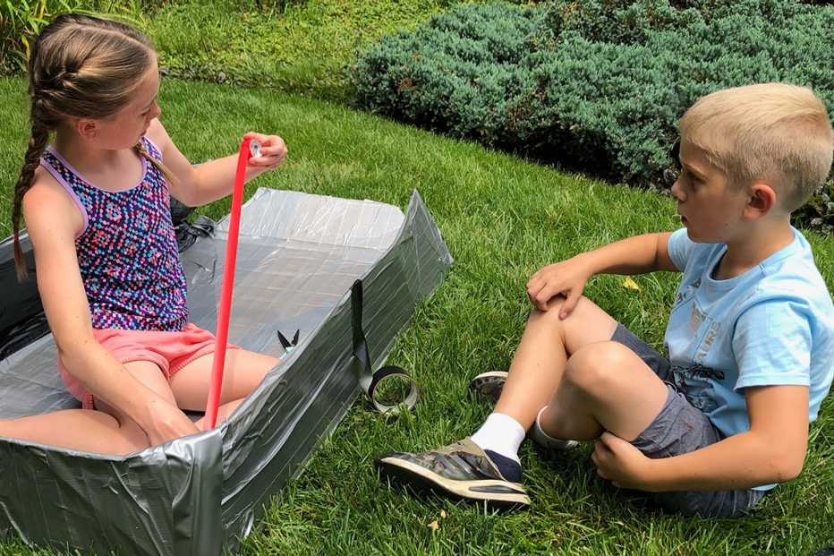 two children build a boat with duct tape