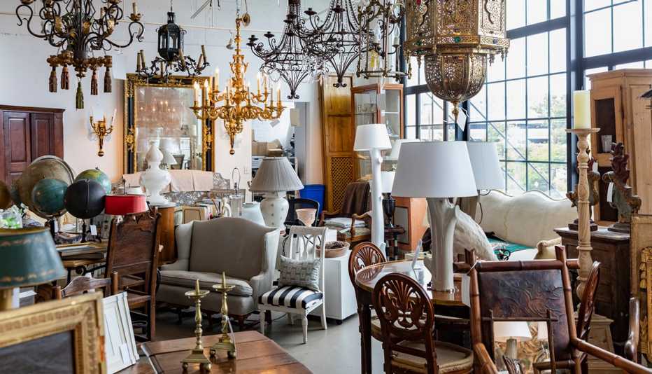 a storeroom full of antique lamps and furniture