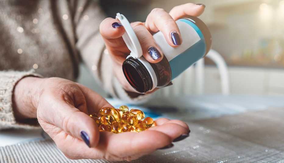 Woman emptying a pill bottle into her hand