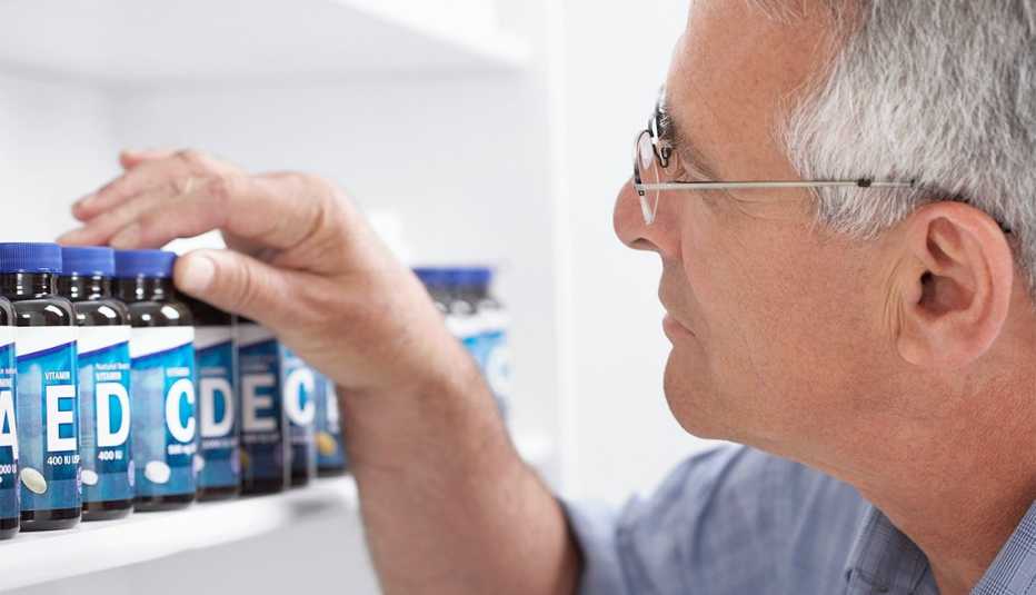 Man looks at supplement bottles