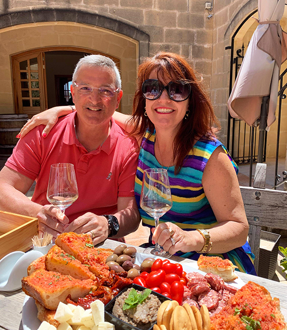 peter and eileen azzopardi enjoy an italian feast and wine on an outdoor patio
