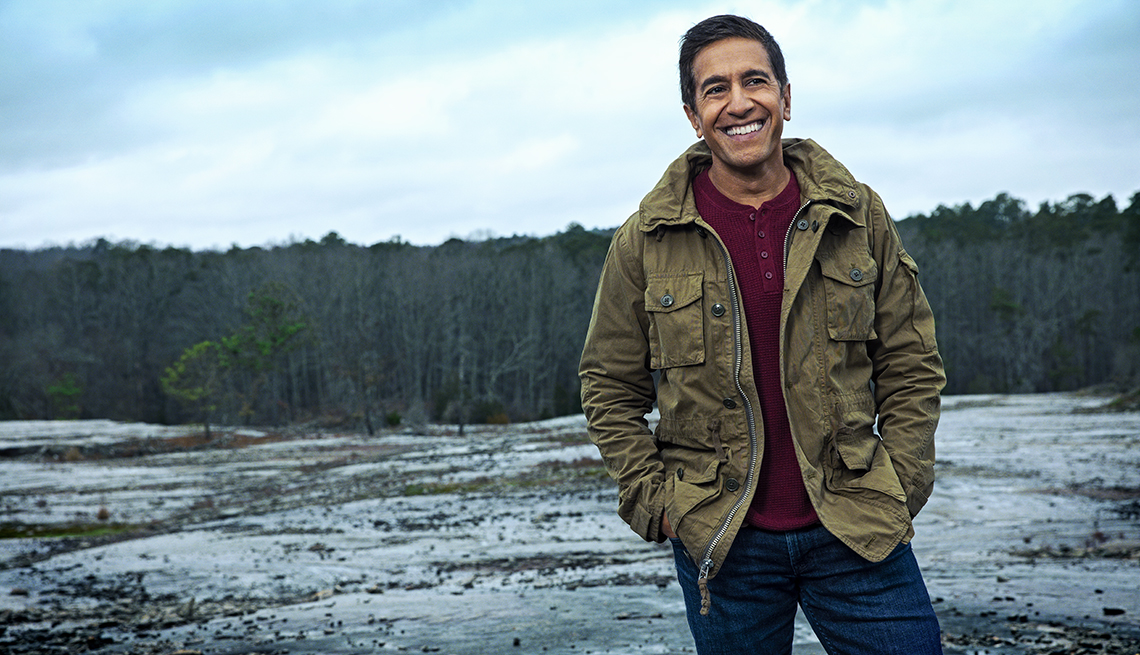 doctor sanjay gupta photographed outdoors smiling on a mountain peak