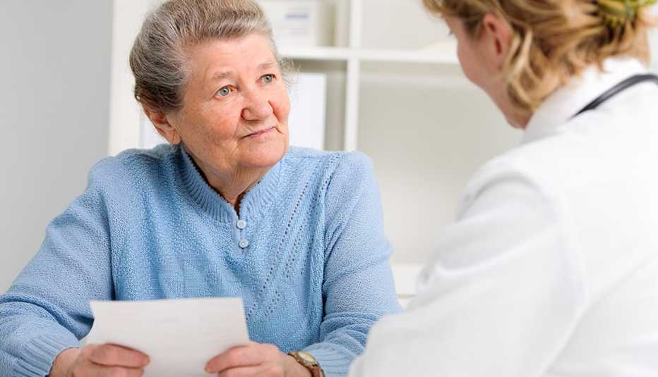 Woman holding a list of questions and talking to her doctor