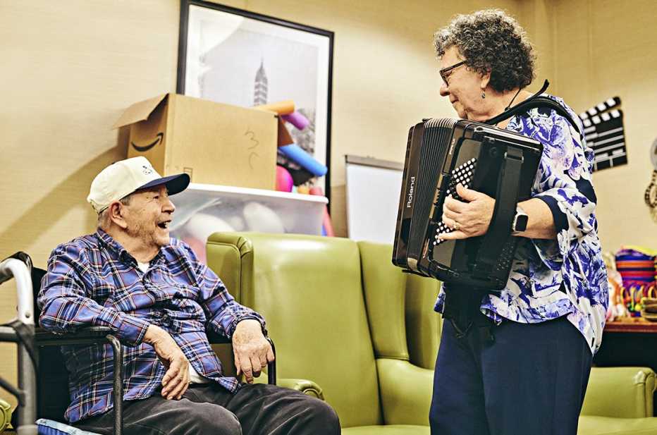 concetta tomaino plays the accordion for a patient in the memory care unit at a new york care facility