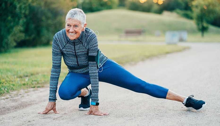 Smiling senior sports woman exercising in the park