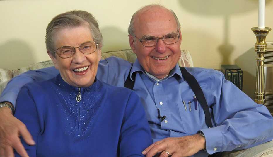 couple sitting together on couch smiling 
