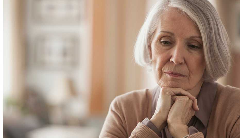 Older woman with chin in hands, looking sad