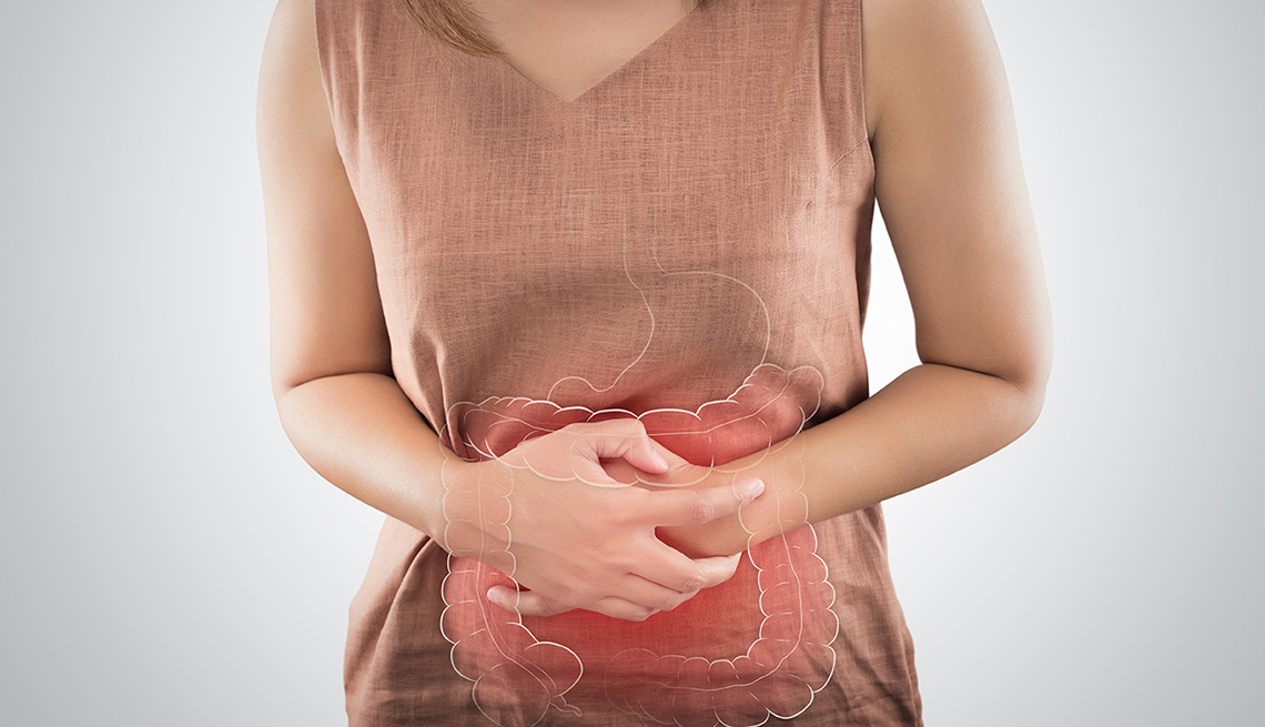 A woman clutching her stomach from a painful colon.