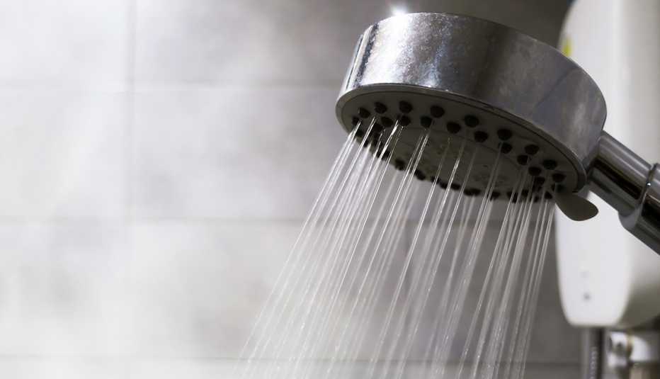 close up of a many small water streams from a shower head in bathroom filled with vapor from the hot temperatures