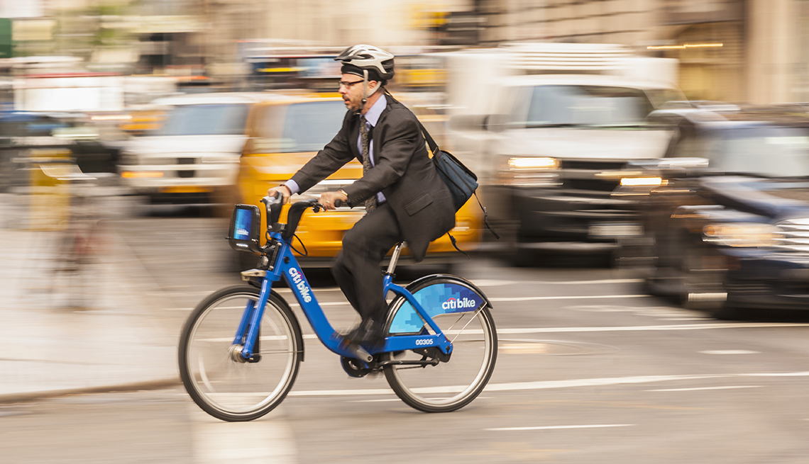 a mature man rides a bike in a city 