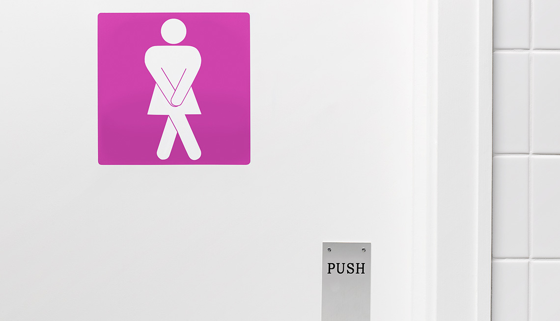 Pink bathroom door sign of a desperate woman needing to urinate.