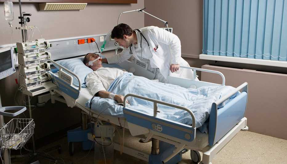 doctor examines a seriously ill patient in an hospital bed