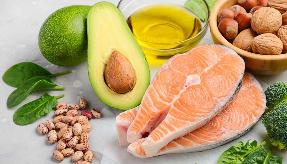 Selection of healthy food for heart, includes salmon, nuts, avocado and olive oil