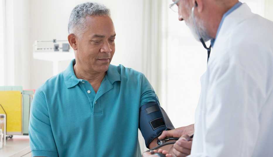 A doctor checks the blood pressure of male patient