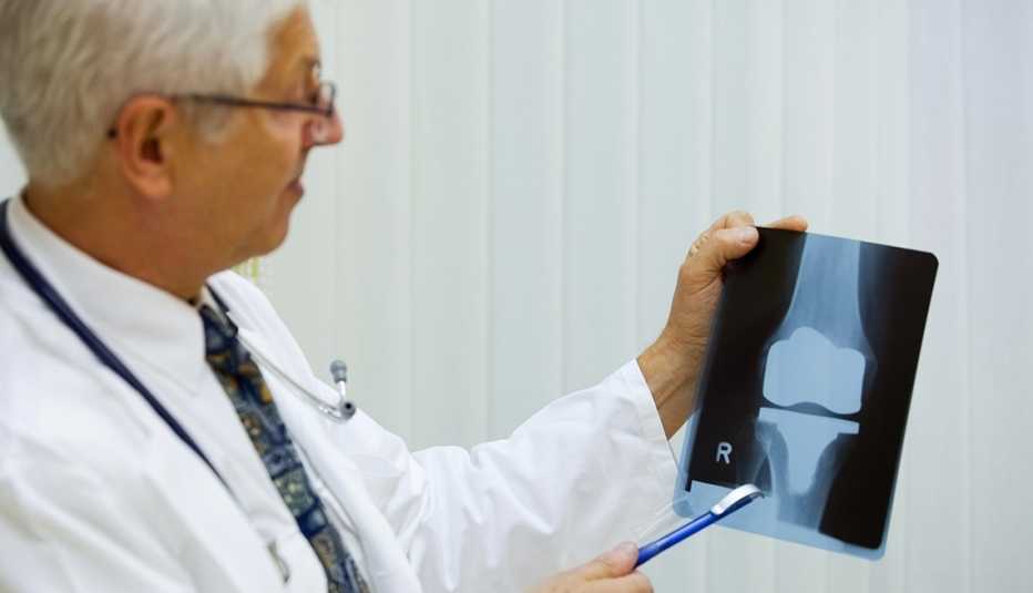 A doctor is examining a x-ray image of an artificial knee