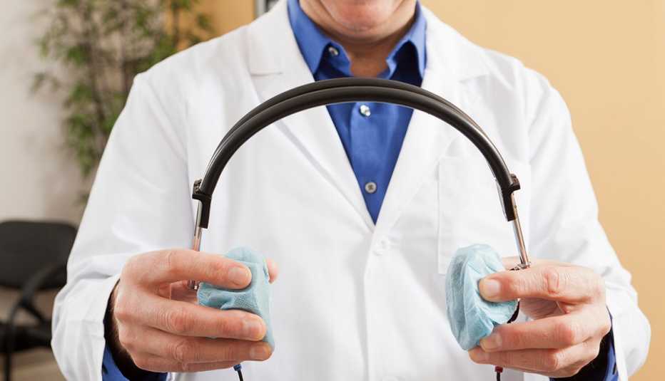 Doctor holding a pair of headphones for a hearing test.