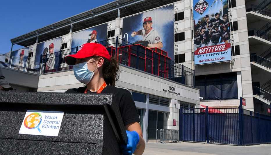 a masked and gloved worker helps load a crate of supplies from the world central kitchen outside nationals park in washington dc