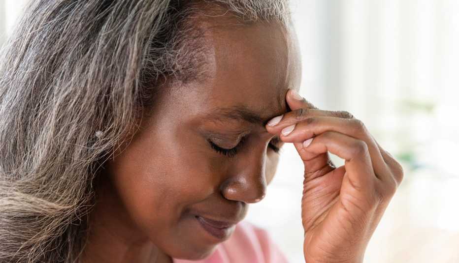 Older African American woman holding her brow as if she has a headache