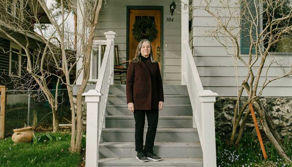 a woman standing on the front steps of her house