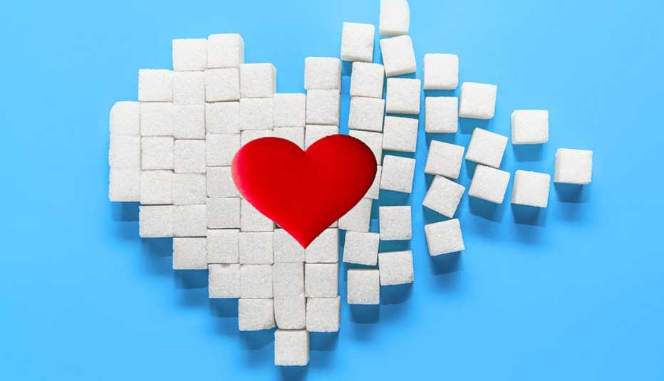 Red heart on heart made of sugar cubes on a blue background.