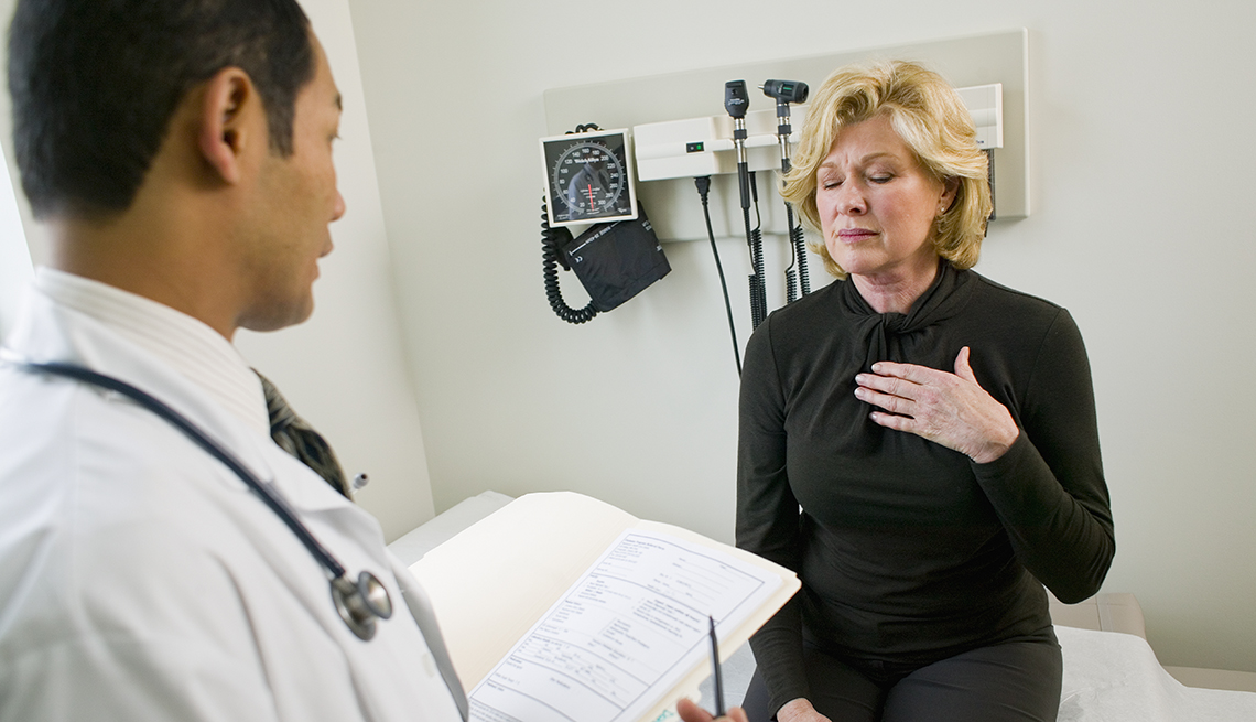 woman talking with her doctor, explaining that she has acid reflux
