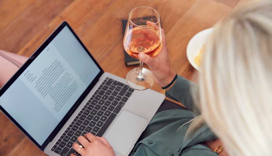 woman working from home, drinking a glass of wine