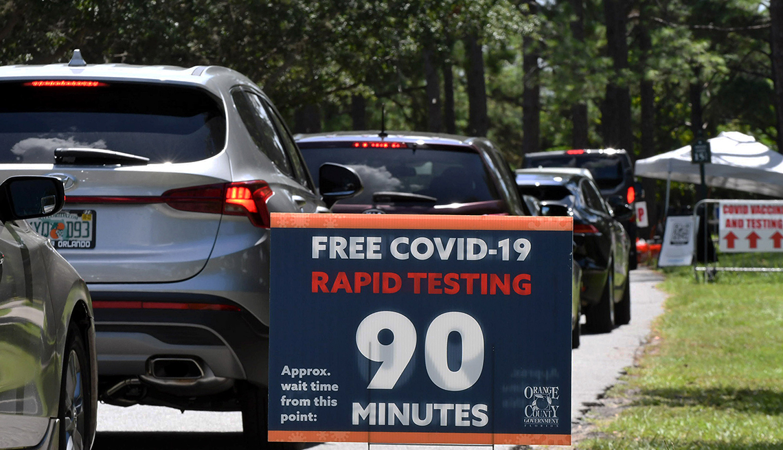 People in cars wait at a COVID-19 testing and vaccination site in Orlando, FL.